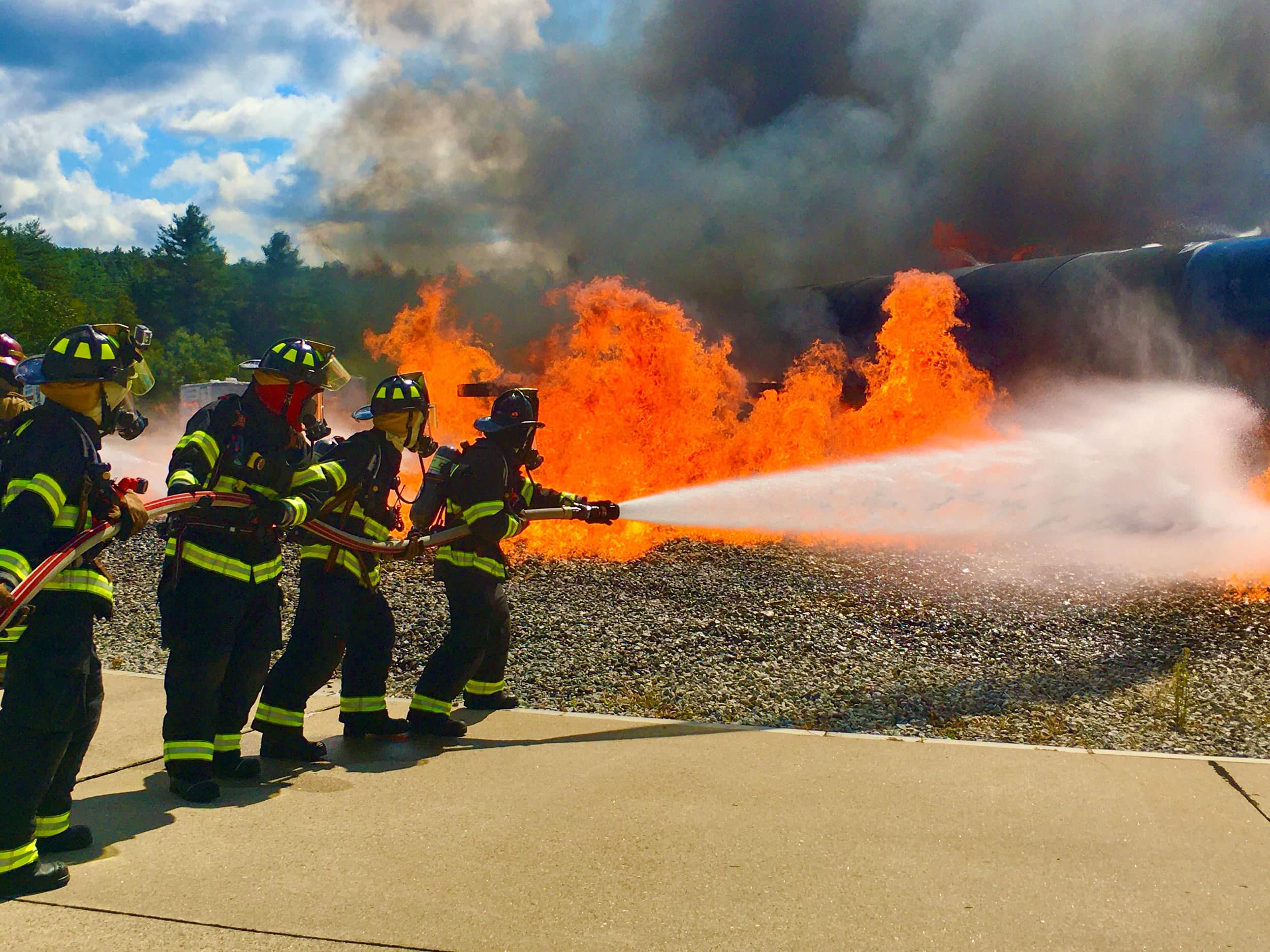 Firefighters extinguishing a large fire during training at PVD Airport